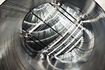 In this view of the KATRIN experiment's main spectrometer, a large metal portal opens to the interior of a large vacuum vessel.